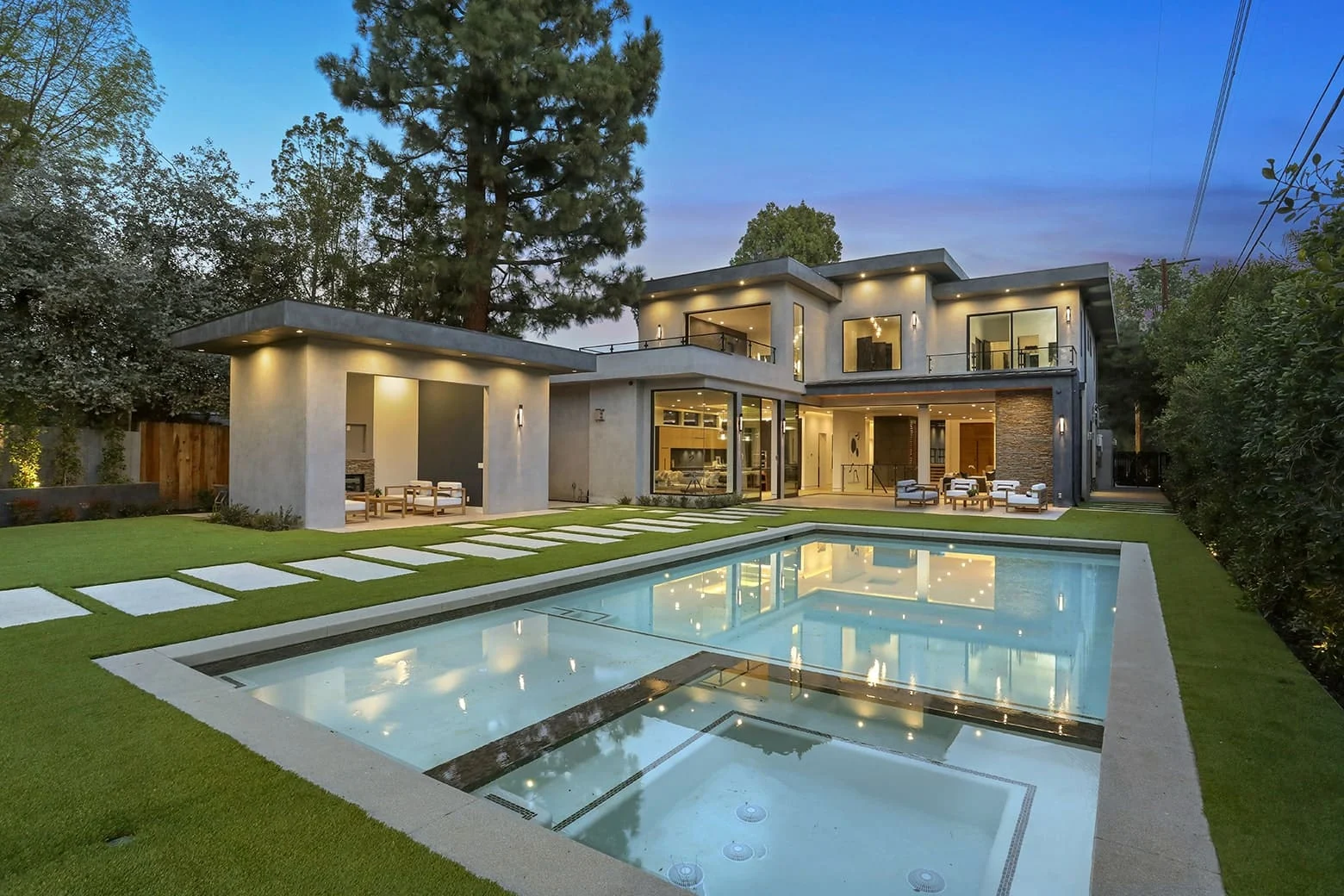 A modern two-story home and pool at dusk, built by Regal Construction & Remodeling